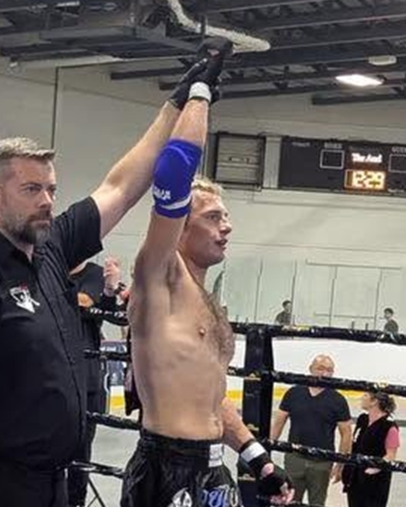 Blake Miller centered with his hand raised after a Muay Thai victory